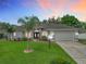 Charming single-story home with a well-manicured lawn, double-door entryway, and a two-car garage at 3534 Woodley Park Pl, Oviedo, FL 32765