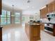 Gourmet kitchen boasts wooden cabinets, granite counters, stainless steel appliances, and center island at 3534 Woodley Park Pl, Oviedo, FL 32765