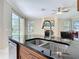 Granite countertop island with sink and dishwasher showcases the kitchen, with a view of the fireplace at 3534 Woodley Park Pl, Oviedo, FL 32765