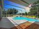 Screened-in pool area with a water feature overlooking a serene lake and fountain at 3534 Woodley Park Pl, Oviedo, FL 32765