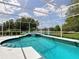 Inviting screened-in pool area overlooking a serene lake, perfect for relaxation and outdoor enjoyment at 3534 Woodley Park Pl, Oviedo, FL 32765