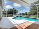 Outdoor swimming pool with fountain and covered patio with a view of the lake at 3534 Woodley Park Pl, Oviedo, FL 32765