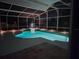 Enclosed pool area with a hot tub and lake views, illuminated for a peaceful evening swim at 3534 Woodley Park Pl, Oviedo, FL 32765