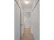 Hallway view with closet doors leading to the bathroom with tiled floor and neutral colors at 3606 S Peninsula Dr # 707, Port Orange, FL 32127
