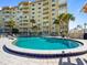 Relaxing pool area surrounded by mature palm trees and lounge chairs at 3606 S Peninsula Dr # 707, Port Orange, FL 32127