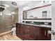 Main bathroom featuring a double sink vanity, glass shower, and wood look flooring at 3889 Biscayne Dr, Winter Springs, FL 32708