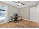 Bedroom featuring wood-look floors, ceiling fan, desk, and a glimpse of the pool through the window at 3889 Biscayne Dr, Winter Springs, FL 32708