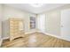 Bedroom featuring wood-look floors, white trim, and wardrobe with full mirror at 3889 Biscayne Dr, Winter Springs, FL 32708