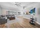 Open living room featuring wood floors, a ceiling fan, and sliding glass doors to a screened-in porch at 3889 Biscayne Dr, Winter Springs, FL 32708