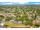 Aerial view showcasing a residential area surrounded by mature trees and a tranquil pond in the distance at 4219 Lillian Hall Ln, Orlando, FL 32812