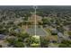 Aerial view shows a lot surrounded by green trees, a large pond, and beautiful neighboring houses at 4219 Lillian Hall Ln, Orlando, FL 32812