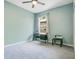 A clean and bright bedroom with blue walls, ceiling fan, and a work desk at 4219 Lillian Hall Ln, Orlando, FL 32812