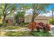 Charming single-story home featuring a well-maintained lawn, mature trees, and colorful landscaping at 4219 Lillian Hall Ln, Orlando, FL 32812