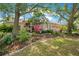 Landscaped front yard with mature trees, colorful plantings, and a well-manicured lawn at 4219 Lillian Hall Ln, Orlando, FL 32812
