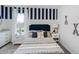Charming bedroom with striped accent wall, comfortable bed, and stylish nautical decorations at 4622 Barberry Ave, Lakeland, FL 33811