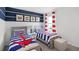 Nautical themed bedroom featuring two twin beds with blue and white striped bedding and red anchor accents at 4622 Barberry Ave, Lakeland, FL 33811