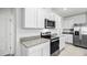 Modern kitchen features stainless steel appliances, granite countertops, and white cabinetry at 4622 Barberry Ave, Lakeland, FL 33811