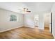 Bright bedroom with wood-look floors, ceiling fan, and an ensuite bathroom at 5162 Tellson Pl, Orlando, FL 32812