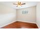A well-lit bedroom featuring neutral walls, wood floors, a window, and a ceiling fan at 5162 Tellson Pl, Orlando, FL 32812