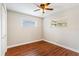 Bright bedroom featuring neutral walls, wood floors, a ceiling fan, and two windows at 5162 Tellson Pl, Orlando, FL 32812