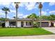 Well-maintained single-story house with landscaped front yard, mature trees, and an attached garage at 5162 Tellson Pl, Orlando, FL 32812