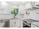 Close up on the kitchen features white cabinets, granite countertops, and stainless steel appliances at 5162 Tellson Pl, Orlando, FL 32812
