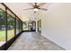 Spacious covered lanai with tile flooring, ceiling fans, and screened windows at 5162 Tellson Pl, Orlando, FL 32812
