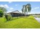 Landscaped backyard with black metal fence and enclosed lanai overlooking the pond at 525 Hardwood Cir, Orlando, FL 32828