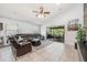 Bright living room featuring a large leather sofa, tile flooring, and access to the screened patio at 525 Hardwood Cir, Orlando, FL 32828