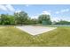 Sand volleyball court surrounded by lush green grass with mature trees providing shade in a beautiful park-like setting at 525 Hardwood Cir, Orlando, FL 32828