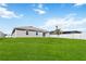 Expansive backyard featuring a lush green lawn with a new tree and partial fencing for privacy at 5347 Travertine St, Mount Dora, FL 32757