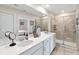 Bathroom featuring double sinks, white cabinetry and a glass-enclosed shower at 5347 Travertine St, Mount Dora, FL 32757