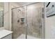 Tiled shower in a bathroom with glass door, shelving, and neutral-colored tiles at 5347 Travertine St, Mount Dora, FL 32757