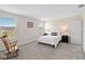 Bright bedroom with a rocking chair, neutral walls, and carpeted flooring at 5347 Travertine St, Mount Dora, FL 32757