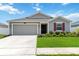 Charming single-story home featuring a neutral color scheme, attached garage, and manicured lawn at 5347 Travertine St, Mount Dora, FL 32757
