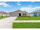 Attractive one-story home featuring a lush lawn, driveway and covered entryway at 5347 Travertine St, Mount Dora, FL 32757