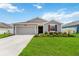 Charming one-story home featuring a lush lawn, driveway and covered entryway at 5347 Travertine St, Mount Dora, FL 32757