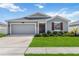 Charming single-story home with a well-manicured lawn, attached garage, and red accent shutters at 5347 Travertine St, Mount Dora, FL 32757