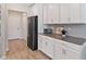 Modern kitchen with white cabinetry, gray countertops, and stainless steel appliances at 5347 Travertine St, Mount Dora, FL 32757