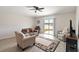 Bright living room with a sliding door, ceiling fan, neutral furniture, and view to the backyard at 5347 Travertine St, Mount Dora, FL 32757