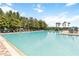 Large community pool with ample lounge chairs and tables, surrounded by lush landscaping at 5347 Travertine St, Mount Dora, FL 32757