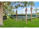 View of the fenced community tennis court, surrounded by mature trees and landscaping at 5347 Travertine St, Mount Dora, FL 32757