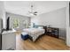 Bright bedroom with light wood floors, fan, and well-lit windows with view of trees at 561 Pinebranch Cir, Winter Springs, FL 32708