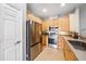 Well-lit kitchen featuring stainless steel appliances and light wood cabinetry and tile flooring at 561 Pinebranch Cir, Winter Springs, FL 32708