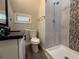 Modern bathroom featuring tiled shower with new fixtures, granite countertop, and updated vanity at 613 Michigan Ave, St Cloud, FL 34769