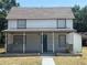 Charming two-story home featuring a covered front porch and a well-maintained lawn at 613 Michigan Ave, St Cloud, FL 34769