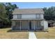 Charming two-story home featuring a covered front porch and a well-maintained lawn at 613 Michigan Ave, St Cloud, FL 34769