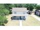 A charming two-story home featuring a cozy front porch with a driveway and lush green surroundings at 613 Michigan Ave, St Cloud, FL 34769