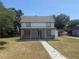 Charming two-story home featuring a covered front porch and a well-maintained lawn at 613 Michigan Ave, St Cloud, FL 34769