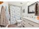 Well-lit bathroom featuring a shower with blue curtain, granite vanity, and stylish tile flooring at 702 Glasgow Ct, Winter Springs, FL 32708